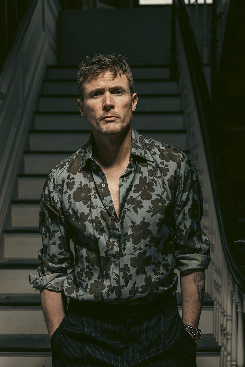 Man in floral shirt on staircase