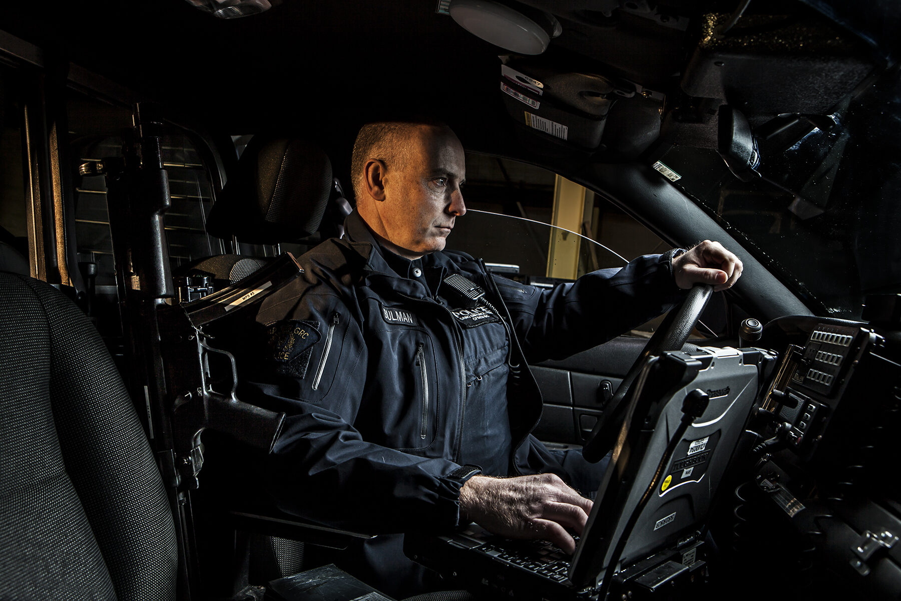 Police officer in cruiser at night