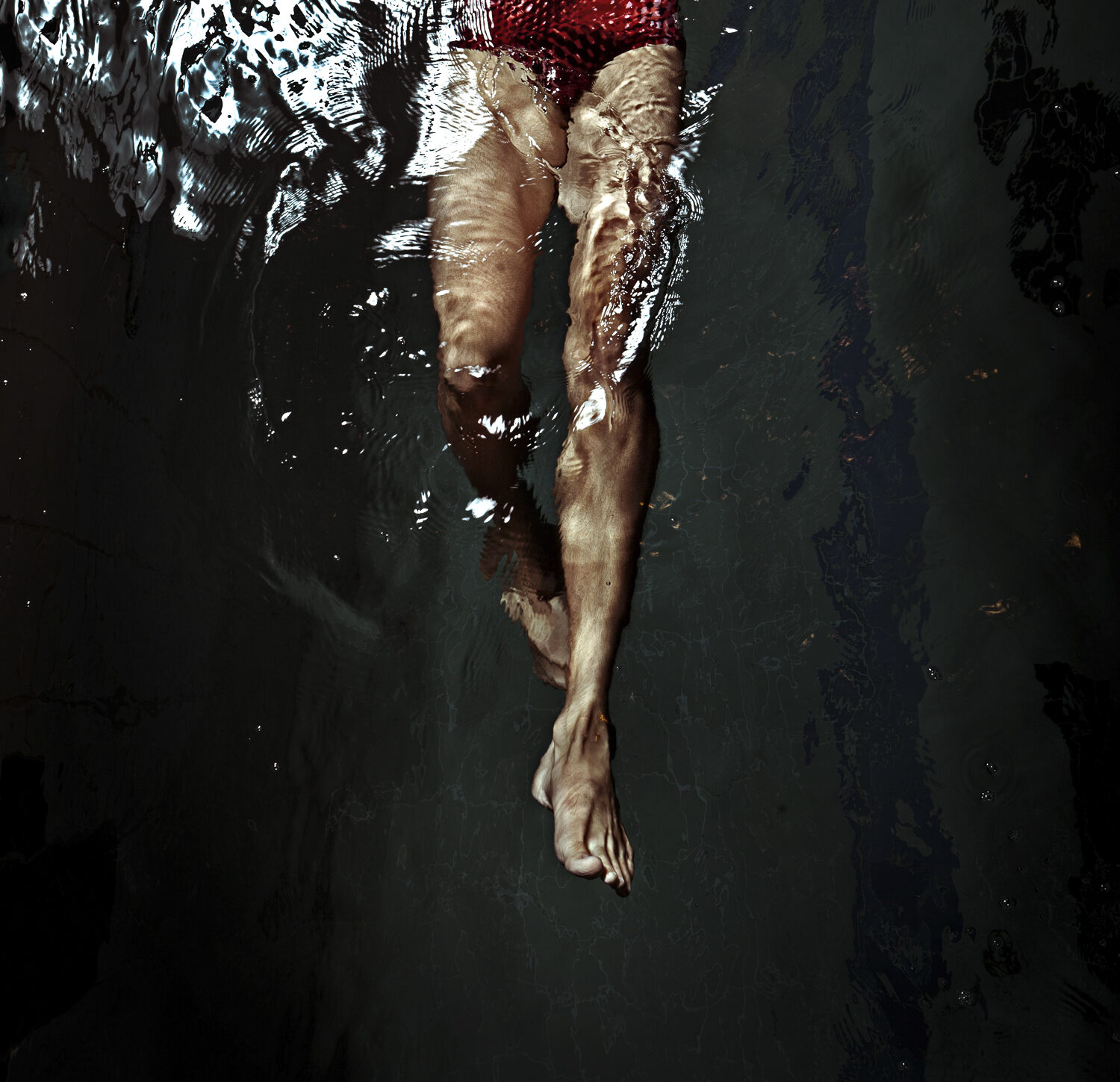 Swimmer underwater, red and shadow